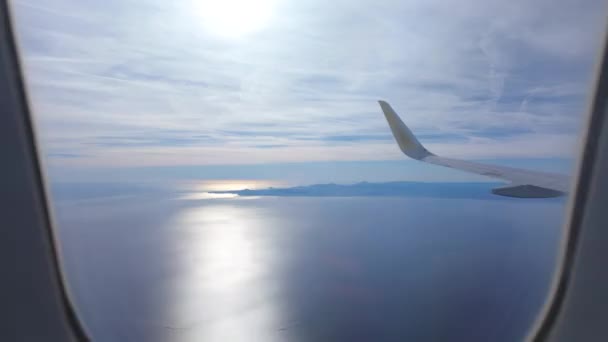 落日时飞机在海面上盘旋的一个环状片断 接近陆地 通过飞机的窗户可以看到 — 图库视频影像