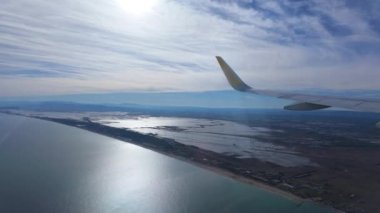 Uçak kanadı Valencia havaalanına iniyor, Albufera silueti uzaktan görülebiliyor..