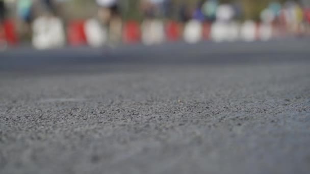 バックグラウンドの鋭いアスファルト前景とぼやけたランナーと都市マラソンのHlgビデオループ — ストック動画
