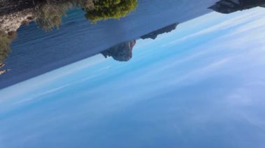 Video kamerayı gökyüzünden denize döndürür, uzak adayı ortaya çıkarır..