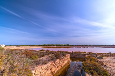 Güzel uzun pozlama fotoğrafları dingin bir günbatımı görüntüsünde canlı tuz tavaları yakalar..
