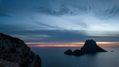 Es Vedra, İbiza 'da gün batımının çarpıcı zamanlaması. Renkli bulutlar ve parlayan ufuklarla..