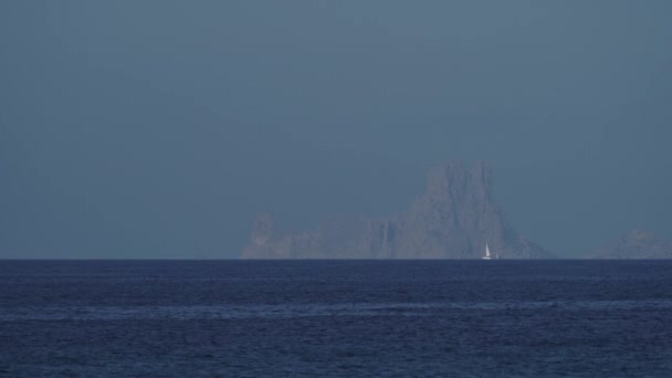 イビサ近郊の青い海を航行する帆船で ヴェーダラの岩の作風が見える テキストオーバーレイに最適 — ストック動画