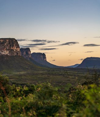 Dağ hatları ve yumuşak gökyüzü ile huzurlu bir gün batımı..