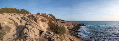 Resimli kayalık kıyılar zaman içinde aşındı, açık gökyüzünün altında..