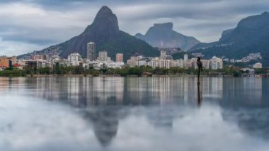 Bir karabatak Rio de Janeiro 'nun üzerinde yükselen fırtınayı izliyor. Dağların altına kurulmuş bir şehir..