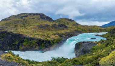 Turkuaz nehri engebeli dağların arasından akar..