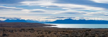 Stunning cloudscape over tranquil Patagonian lake and peaks. clipart