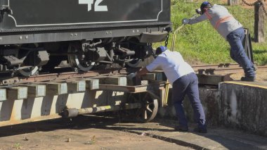 Tiradentes, Brezilya 'daki işçiler, tarihi Maria Fumaca trenini manuel olarak dairesel bir platformda döndürerek, 14 Haziran 2024' teki bir sonraki yolculuğu için hazırlıyorlar..