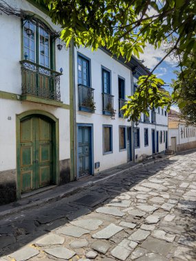 Tarihi bina cepheleri, sakin mavi gökyüzünün altında bir kaldırım taşı caddesi..
