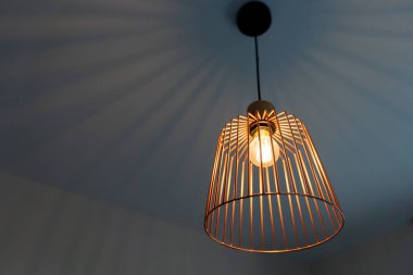 Geometrik kafes kolye ışığı tavana sanatsal gölgeler bırakır ve çağdaş bir ortam yaratır..
