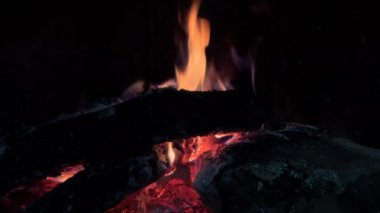 Dans eden alevlerle dolu sıcacık bir şömine videosu karanlıkta sıcak, davetkar bir atmosfer yaratır..