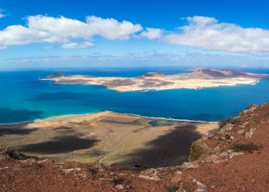 Okyanus ve engebeli manzaranın havadan görünüşü, Lanzarote 'den La Graciosa' nın doğal güzelliğini ve huzurunu vurguluyor.