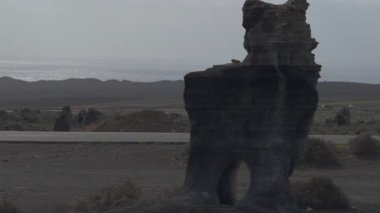 Video, Lanzarote 'de eski bir taş ocağında delik olan eşsiz bir taş oluşumunu gösteriyor. Yakınlardaki yoldan arabalar geçerken..