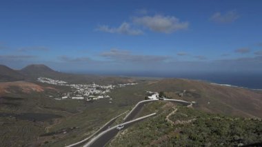 Bir video Lanzarote 'de virajlı bir yolda arka planda okyanusla yükselen bir arabayı gösteriyor..