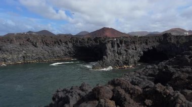 Lanzarotes 'un çarpıcı videosunda Los Hervideros volkanik kayalara çarpan turistleri ve ağır çekim dalgalarını gösteriyor..