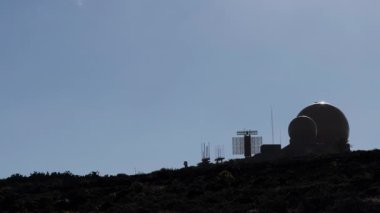 Bir video, açık ve mavi gökyüzüne karşı bir dağda dönen yuvarlak bir askeri radarı ve bir diğerini gösteriyor..