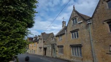 Bourton-On-the-Water, İngiltere 'deki tarihi Cotswold köyü evleri hızla kayan bulutların altında göze çarpıyor ve resimli mimariyi ön plana çıkarıyor..