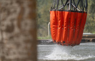 Bir Bambi kovası suyla doludur, hızlı hava itfaiyesi operasyonları için çok önemlidir..
