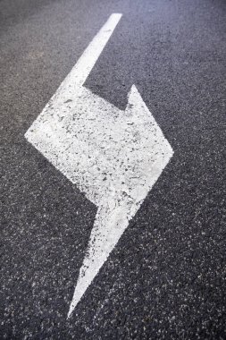 Detail of a traffic signal on a road, direction arrow and information