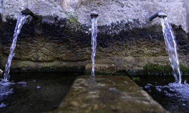 Sabit su, su ve içeceklerle dolu eski çeşmenin ayrıntıları.