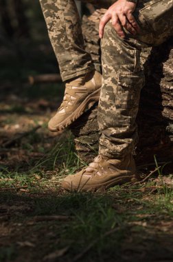 Özel üniformalı ve koruyucu taktik spor ayakkabılı bir asker. Haki ve yeşil giysili askerler için su geçirmez spor ayakkabılar.