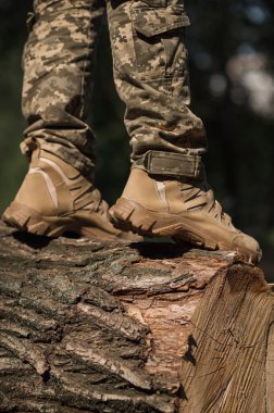Özel üniformalı ve koruyucu taktik spor ayakkabılı bir asker. Haki ve yeşil giysili askerler için su geçirmez spor ayakkabılar.