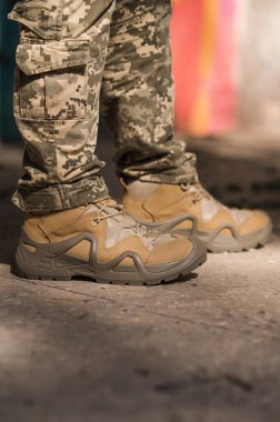 Özel üniformalı ve koruyucu taktik spor ayakkabılı bir asker. Haki ve yeşil giysili askerler için su geçirmez spor ayakkabılar.