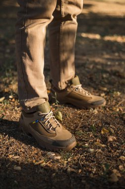 Özel üniformalı ve koruyucu taktik spor ayakkabılı bir asker. Haki ve yeşil giysili askerler için su geçirmez spor ayakkabılar.