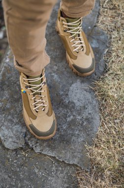 Özel üniformalı ve koruyucu taktik spor ayakkabılı bir asker. Haki ve yeşil giysili askerler için su geçirmez spor ayakkabılar.