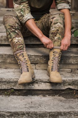 Özel taktiksel haki ayakkabılı bir asker.