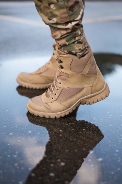 Özel taktiksel haki ayakkabılı bir asker.
