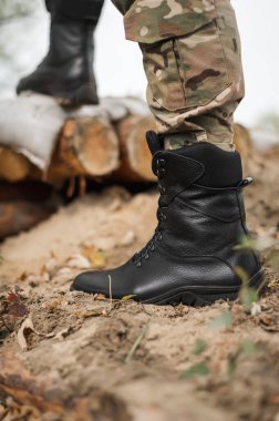 Siperdeki yüksek siyah dantelli deri ayakkabılı bir asker.