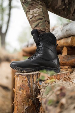 Siperdeki yüksek siyah dantelli deri ayakkabılı bir asker.
