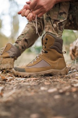 Deri haki rengi yüksek spor ayakkabılı bir asker.