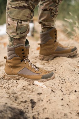 Deri haki rengi yüksek spor ayakkabılı bir asker.