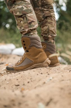 Deri haki rengi yüksek spor ayakkabılı bir asker.