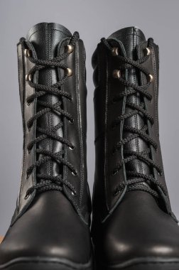 Gri arka planda yüksek siyah deri ayakkabılar.