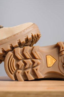 Gri arka planda haki rengi yüksek askeri botlar.