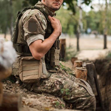 Siperin yanında taktik sırt çantası olan özel üniformalı bir asker.