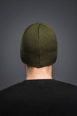 Koyu yeşil, ılık kış şapkalı bir adam.