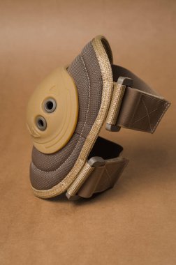 Bej arka planda koruyucu askeri dirseklikler.