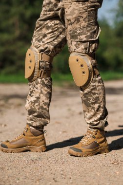 Koruyucu üniformalı asker. Koruyucu kamuflaj üniforması. Askerler için dirseklikler ve dizlikler.