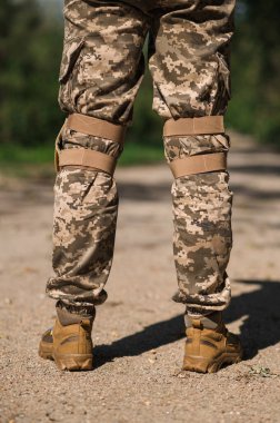 Koruyucu üniformalı asker. Koruyucu kamuflaj üniforması. Askerler için dirseklikler ve dizlikler.