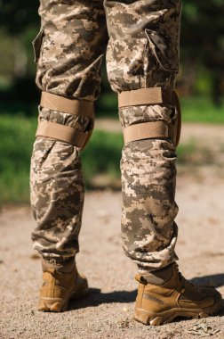 Koruyucu üniformalı asker. Koruyucu kamuflaj üniforması. Askerler için dirseklikler ve dizlikler.