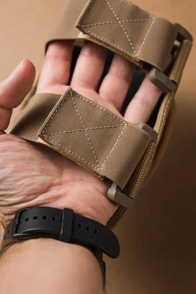 Protective military elbow pads on a beige background
