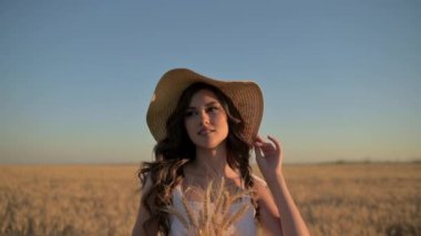 Yeşillik buğday tarlasında bir kadının güzel bir portresi, doğanın huzurunu yansıtıyor.