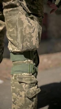 Askeri kullanım için diz koruması ile donatılmış kamuflaj için tasarlanmış taktik pantolonların detaylı bir yakın çekim görüntüsü.