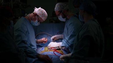 Yetenekli bir cerrah ekibi, yüksek donanımlı bir cerrahi tiyatroda hassas ve karmaşık bir operasyon gerçekleştiriyor.