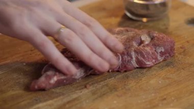 Bu resim, ahşap bir kesme tahtasında çeşitli et türlerini ustalıkla hazırlamak için özel bir tekniği gösteriyor.